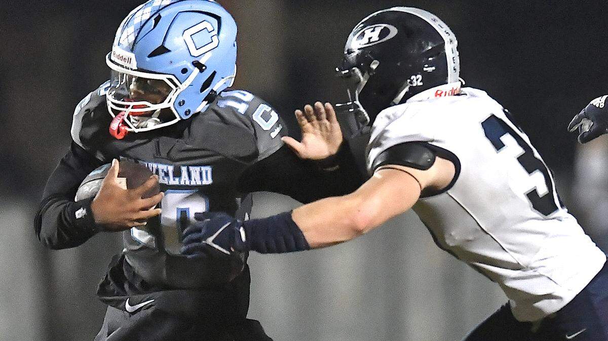 Cleveland quarterback Jackson Byrd (10) runs for yardage against Heritage’s Seth Rucker (32) during the second half. The Cleveland Rams and the Heritage Huskies met in the first round of the NCHSAA 4A playoffs in Clayton, N.C. on November 15, 2024.