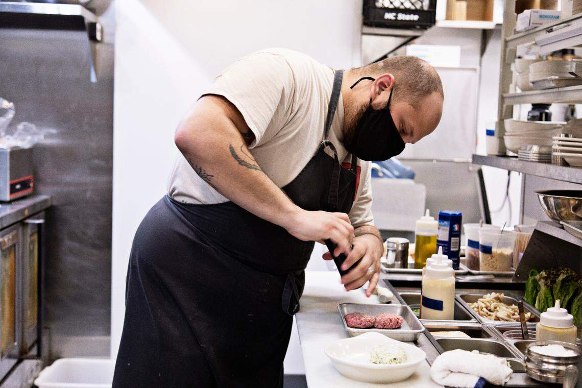 Chef Chris Lopez plates Fine Folk’s Smash Burger on Wednesday, Oct. 6, 2021, in the kitchen at Union Bread.