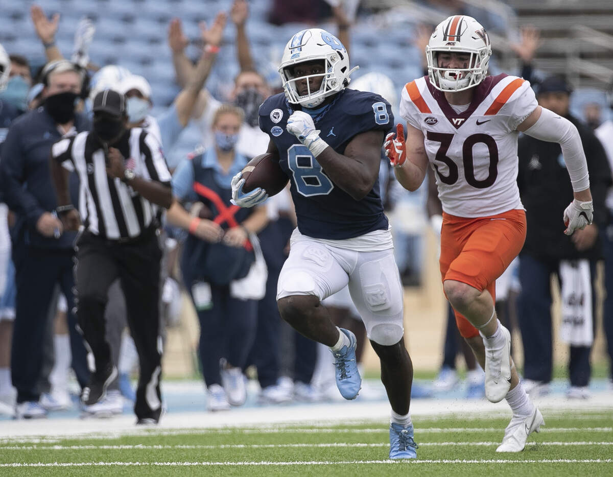 North Carolina’s Michael Carter (8) breaks away from Virginia Tech’s Tyler Matheny (30) for a 62-yard touchdown in the fourth quarter on Saturday, October 10, 2020 at Kenan Stadium in Chapel Hill, N.C.