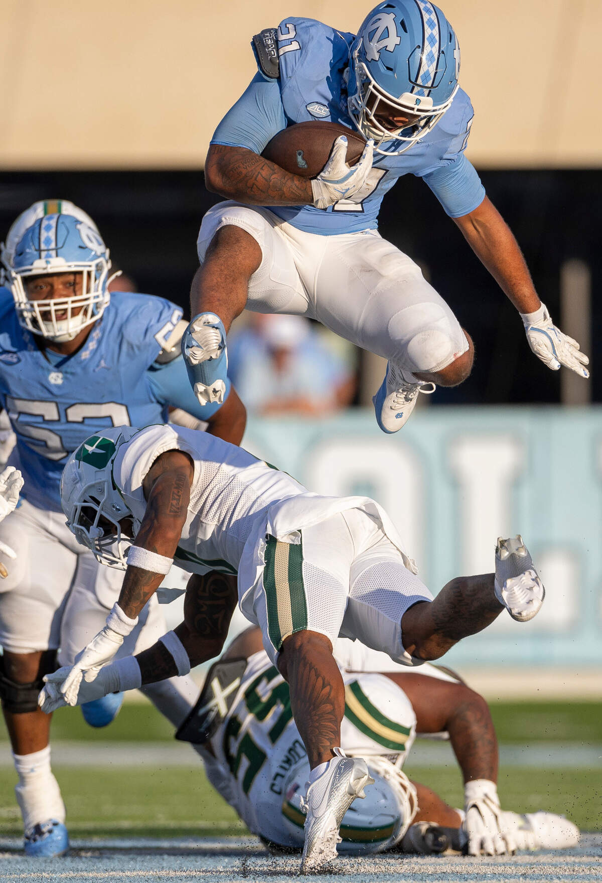 North Carolina running back Davion Gause (21) hurdles over Charlotte defensive back Al-Ma’hi Ali (0) for a 16-yard gain in the fourth quarter on Saturday, September 7, 2024 at Kenan Stadium in Chapel Hill, N.C.