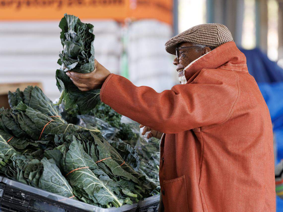 Peggy Goodson purchases collards, a New Year’s tradition, at the State Farmers Market on Tuesday, Dec. 30, 2025, in Raleigh, N.C.