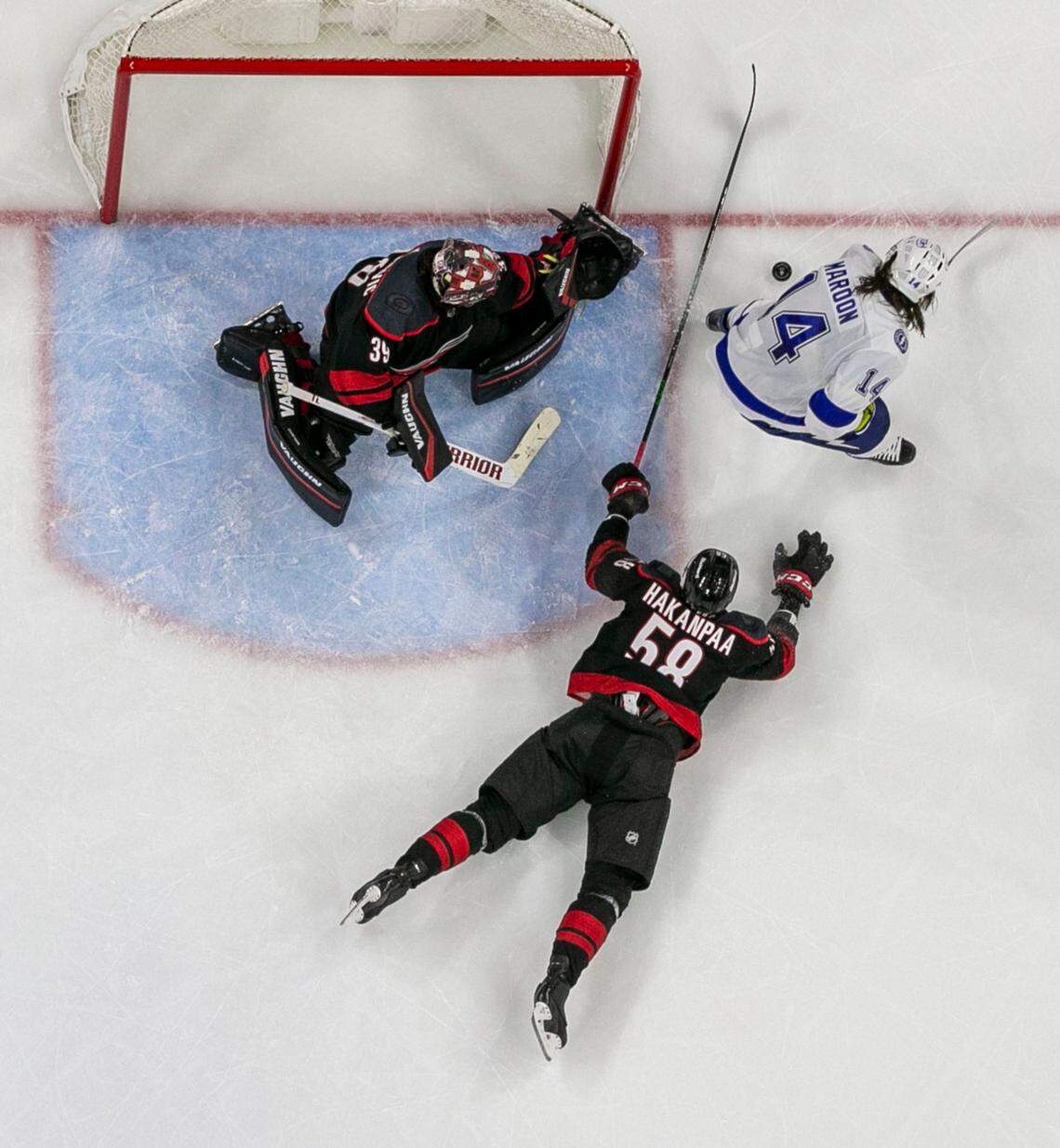 Carolina Hurricanes’ Jani Hakanpaa (58) gets his stick between the goal and Tampa Bay’s Pat Maroon (14) to prevent a score during the third period in game five of their Stanley Cup series against Tampa Bay on Tuesday, June 8, 2021 at PNC Arena in Raleigh, N.C.