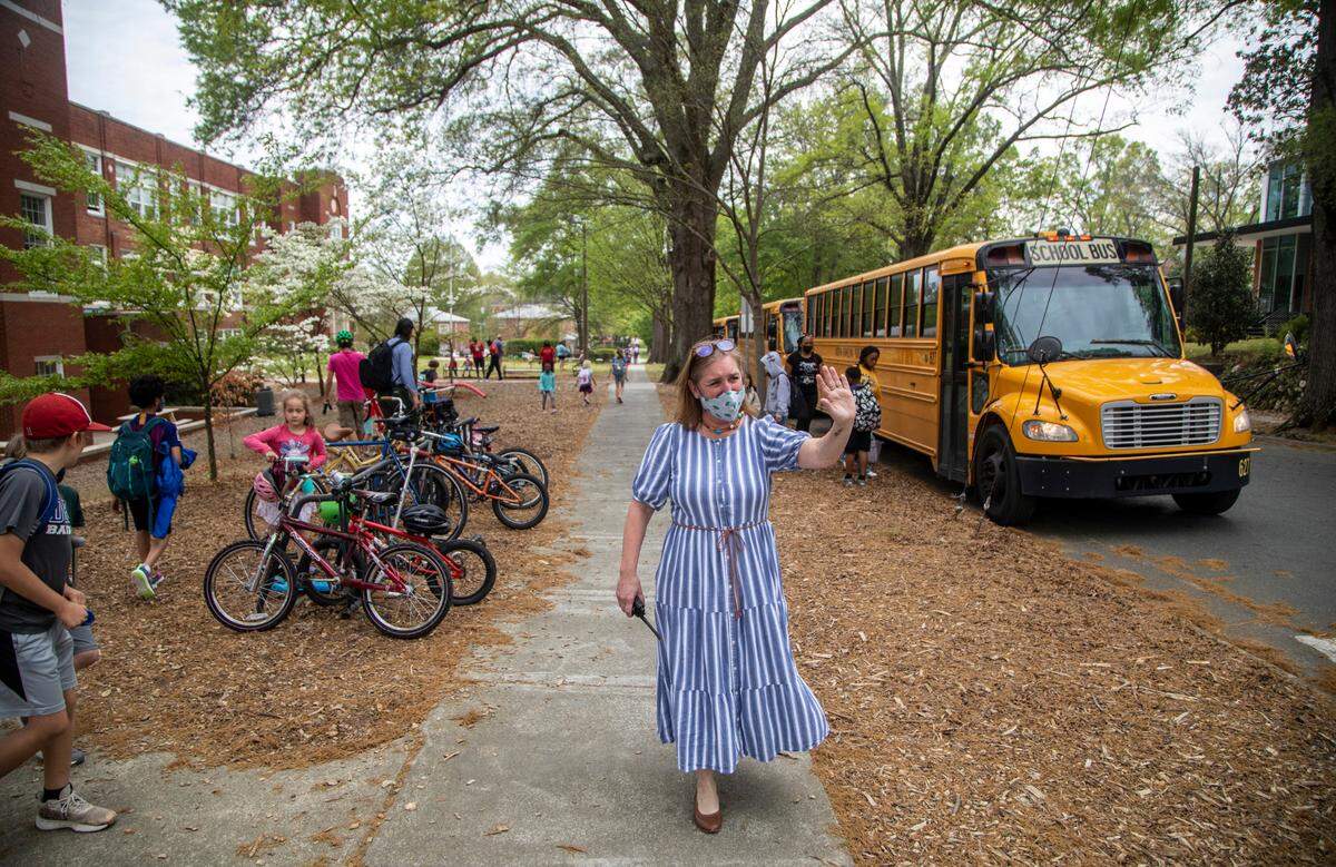George Watts Elementary School Principal Patti Crum waves as students are dismissed Tuesday, April 12, 2022. Durham’s public school system will begin using a new model for assigning students to schools in the 2023-24 school year, in an attempt to increase equity.
