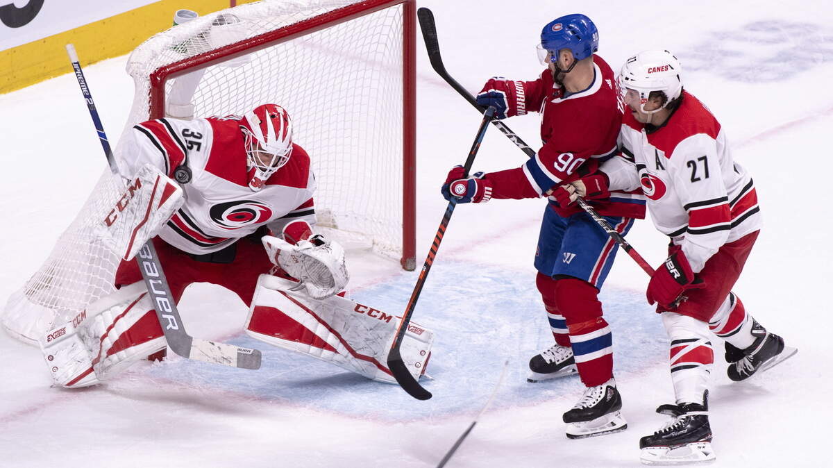 Carolina Hurricanes goaltender Curtis McElhinney makes a save as Montreal Canadiens’ Tomas Tatar looks for the rebound as he is covered by defenseman Justin Faulk during the first period of an NHL hockey game Tuesday, Nov. 27, 2018, in Montreal.