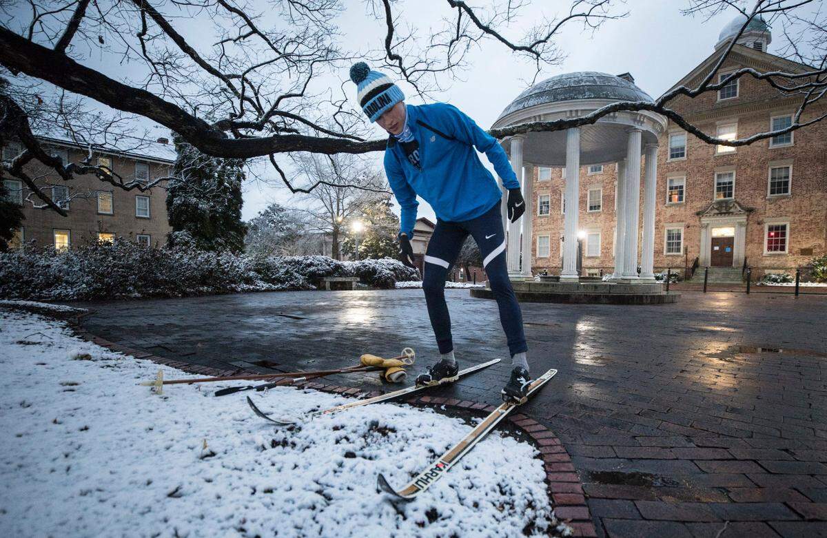 Andrew Thornton, a UNC-Chapel Hill sophomore, adjusts his skis before taking off down McCorkle Place in Chapel Hill, N.C. on Thursday morning, January 28, 2021.