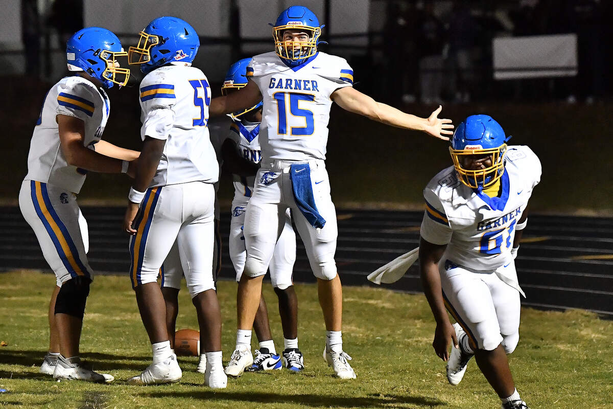 Garner quarterback Christian Ormandy (15) celebrates his touchdown against South Garner with teammates during the first half. The South Garner Titans and the Garner Trojans met in a conference football game in Raleigh, N.C. October 17, 2025