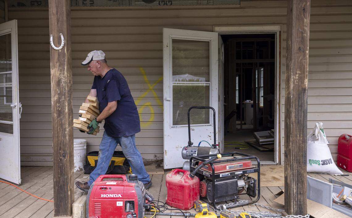 Gary Kellen, a volunteer with Skandia Evangelical Free Church of St. Balaton, Minn., carries lumber into a flooded-out home under repair in the Beacon Village neighborhood on Aug. 13.