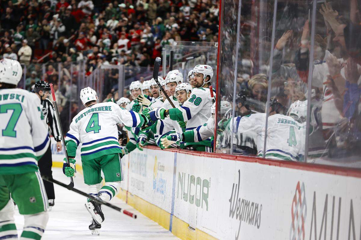 Shayne Gostisbehere (4) of the Carolina Hurricanes celebrates his goal with teammates on the bench during the second period against the Utah Mammoth at Lenovo Center on Jan. 29, 2026 in Raleigh, North Carolina.