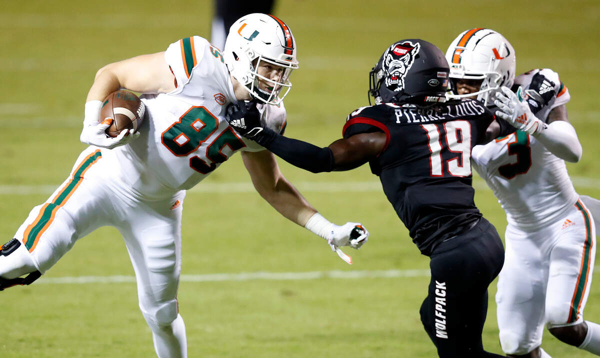N.C. State defensive back Joshua Pierre-Louis (19) gets his hand on Miami tight end Will Mallory (85) as Miami wide receiver Mike Harley (3) tries to block during the first half of N.C. State’s game against Miami at Carter-Finley Stadium in Raleigh, N.C., Friday, Nov. 6, 2020.