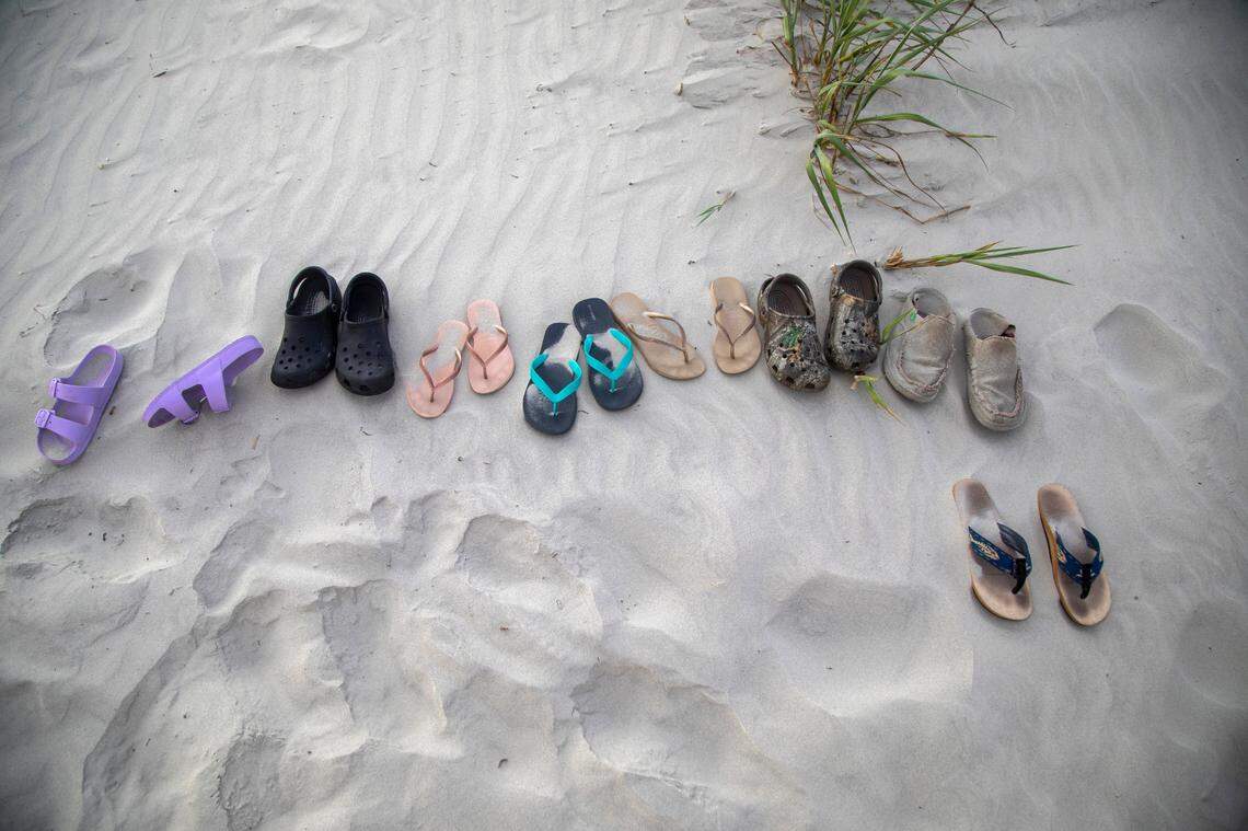 Shoes and sandals lie in the sand on Sunset Beach in June 2022.