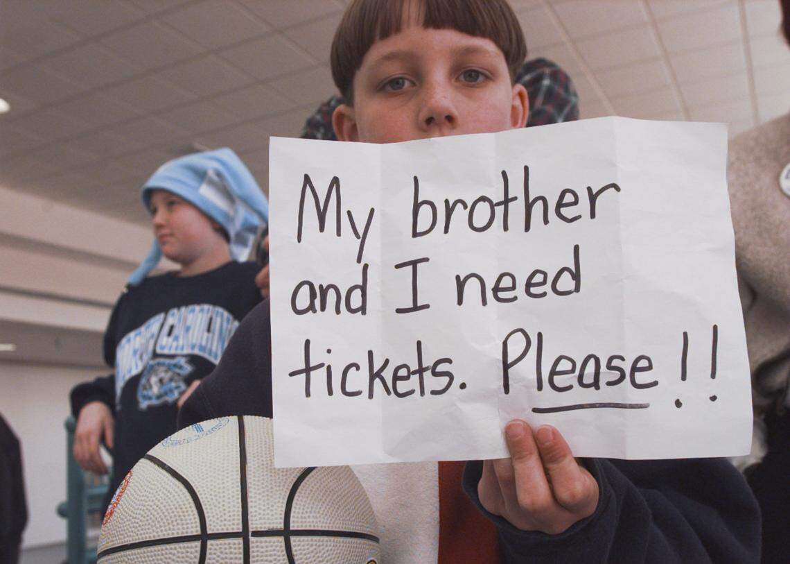 Drew Hicks, 8, from Oxford tries to score from tickets to a Saturday ACC Tournament game for him and his 12 year old brother Brent, background, at the Greensboro Coliseum in 1997.
