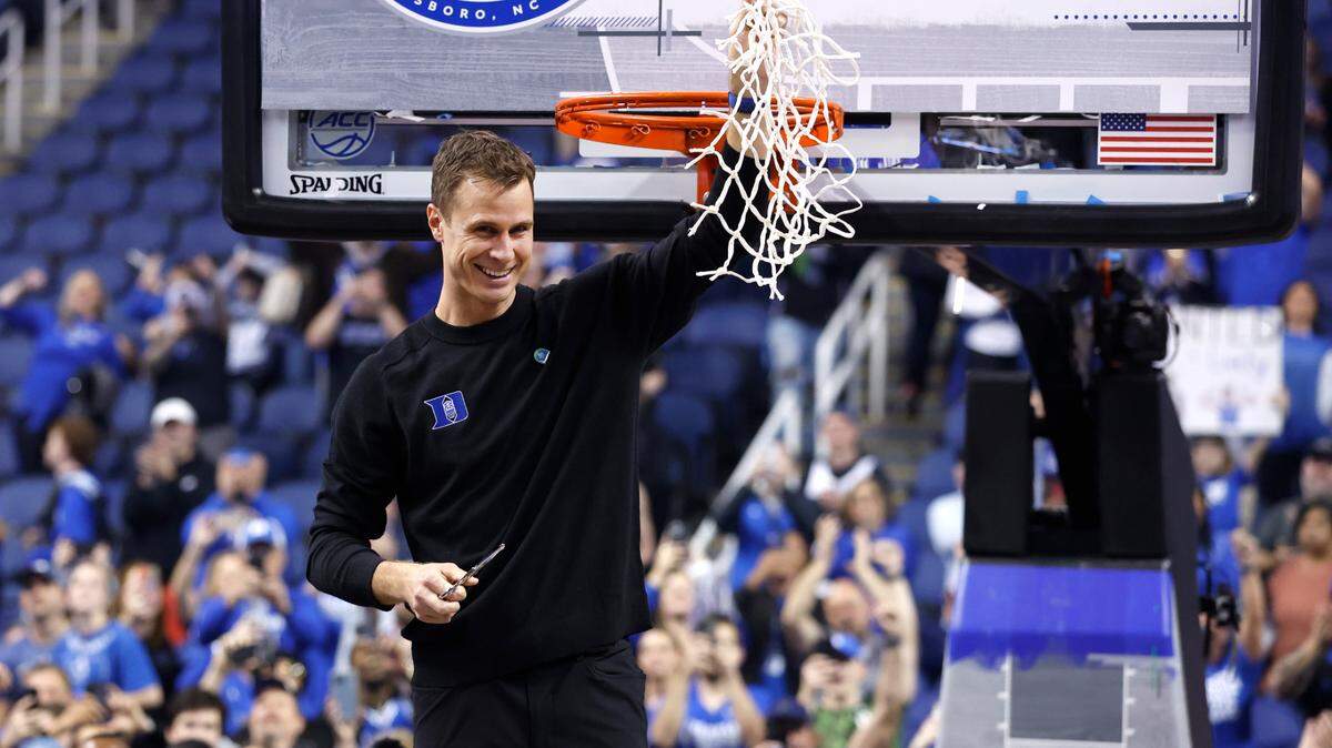 Duke head coach Jon Scheyer celebrates after cutting down the net after Duke’s 59-49 victory over Virginia to win the ACC Men’s Basketball Tournament in Greensboro, N.C., Saturday, March 11, 2023.