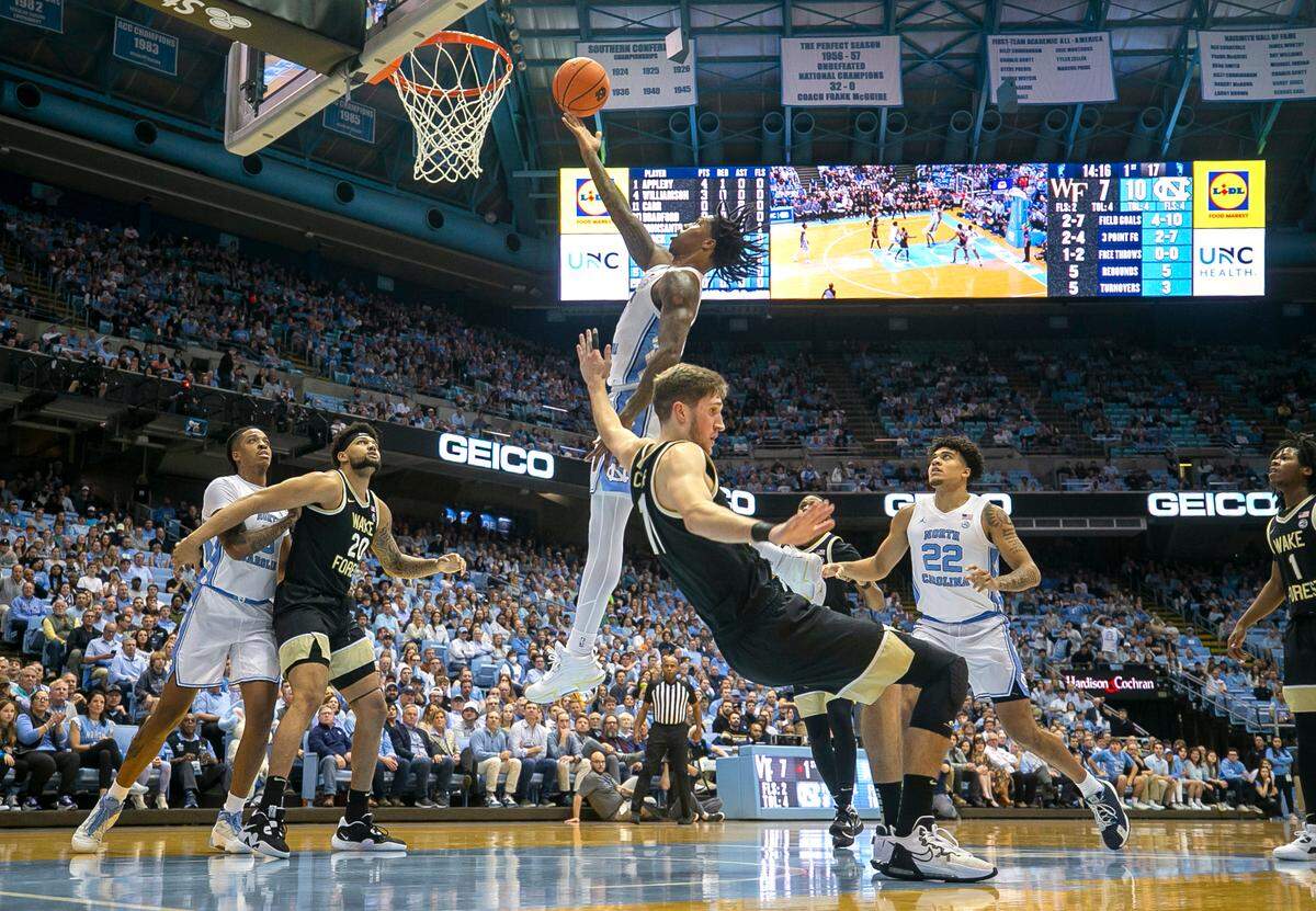 North Carolina’s Caleb Love (2) drives to the basket against Wake Forest’s Andrew Carr (11) in the first half on Wednesday, January 4, 2023 at the Smith Center in Chapel Hill, N.C.