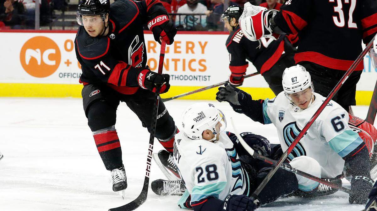 Carolina Hurricanes’ Jesper Fast (71) attempts to clear the puck after Seattle Kraken’s Carson Soucy (28) and Morgan Geekie (67) crashed into the net during the first period of an NHL hockey game in Raleigh, N.C., Sunday, March 6, 2022. (AP Photo/Karl B DeBlaker)
