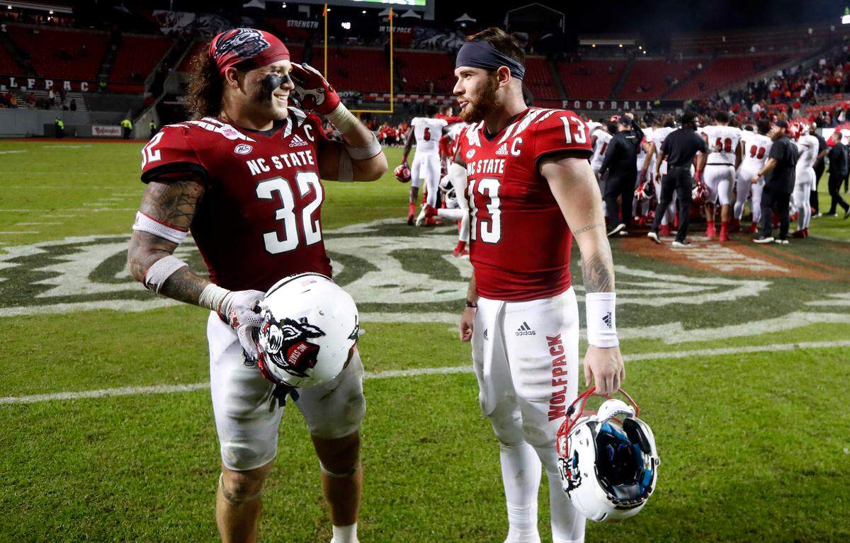 N.C. State linebacker Drake Thomas (32) smiles while talking with quarterback Devin Leary (13) after N.C. State’s 28-13 victory over Louisville at Carter-Finley Stadium in Raleigh, N.C., Saturday, October 30, 2021.