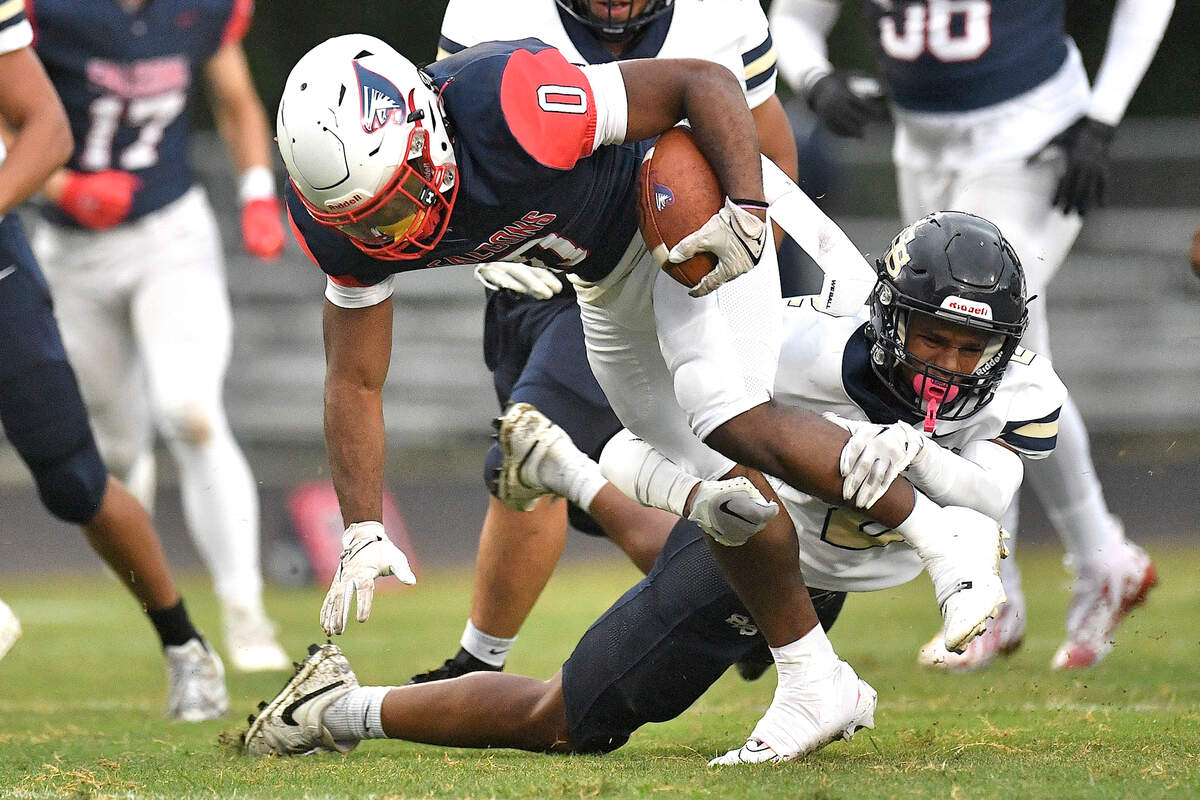 Jordan running back Amareon Blue (0) runs for the first down against the grapple from Smithfield-Selma’s Jamie Groves (2) during the first half. The Durham Jordan Falcons and the Smithfield-Selma Spartans met in a football game in Durham, N.C. on September 13, 2024.