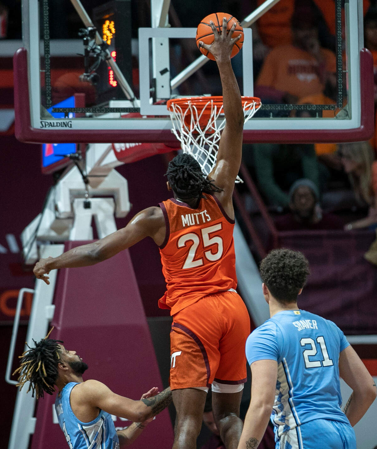 Virginia Tech’s Justyn Mutts (25) goes for a dunk over North Carolina’s R.J. Davis (4) and Will Shaver (21) during the second half on Sunday, December 4, 2022 at Cassell Coliseum in Blacksburg, Va. Mutts lead all scores with 27 points and Virginia Tech to an 80-72 victory.