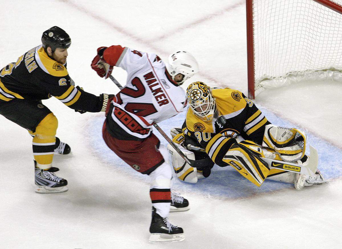 The Carolina Hurricanes’ Scott Walker (24) puts the game-winning shot past the Boston Bruins’ Dennis Wideman (6) and Tim Thomas (30) during overtime period action of Game 7 of an NHL playoff between the Carolina Hurricanes and the Boston Bruins in 2009.