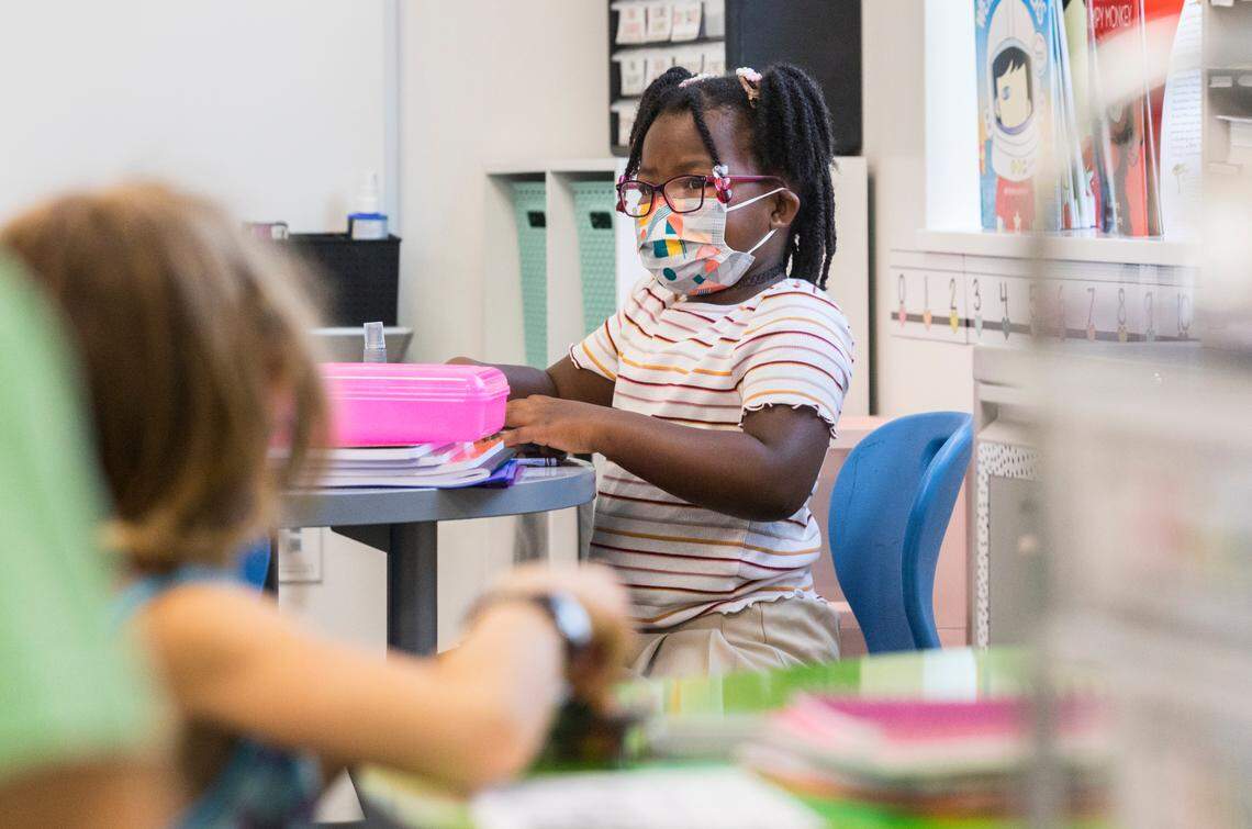 Julianna Robbins, 6, a first-grade student at Conn Elementary School in Raleigh, N.C. prepares her desk for the first day of school, Monday, Aug. 23, 2021.