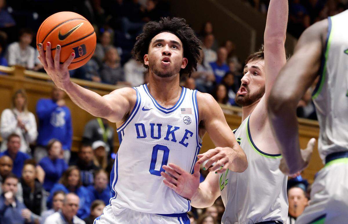 Duke’s Jared McCain (0) drives by Queens’ Jaxon Pollard (22) during the first half of Duke’s game against Queens University at Cameron Indoor Stadium in Durham, N.C., Saturday, Dec. 30, 2023.