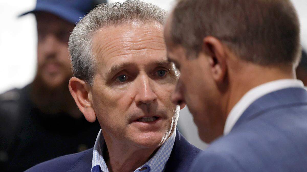 North Carolina athletic director Bubba Cunningham talks with ACC commissioner Jim Phillips before UNC’s game against South Carolina in the Duke’s Mayo Classic at Bank of America Stadium in Charlotte, N.C., Saturday, Sept. 2, 2023.