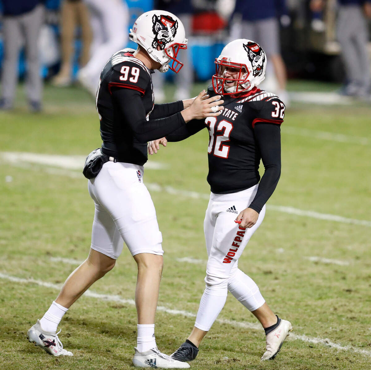 N.C. State’s Trenton Gill (99) celebrates with Christopher Dunn (32) after Dunn made a 32-yard field goal during the second half of N.C. State’s 23-13 victory over Georgia Tech at Carter-Finley Stadium in Raleigh, N.C., Saturday, Dec. 5, 2020. With the field goal, Dunn set the new school record with 56 career field goals.