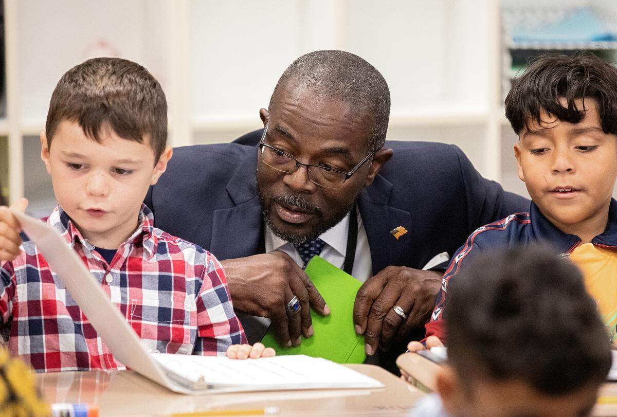 New Wake County Superintendent Robert Taylor speaks with second grade students Felix Moss, left, and Cesar Vera Quinones, right, during a tour of Rolesville Elementary School on his first day on the job on Monday, Oct. 2, 2023, in Rolesville, N.C.