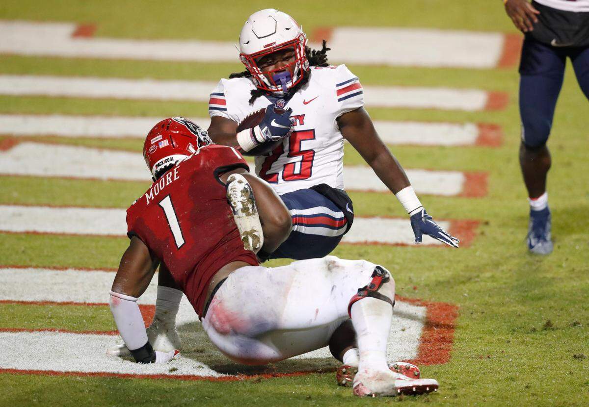 N.C. State linebacker Isaiah Moore (1) tackles Liberty running back Peytton Pickett (25) in the end zone for a safety during the second half of N.C. State’s 15-14 victory over Liberty at Carter-Finley Stadium in Raleigh, N.C., Saturday, Nov. 21, 2020.