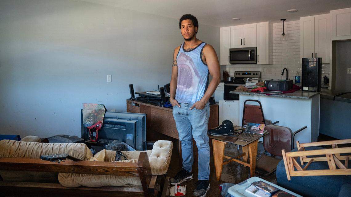 Aidan Akkari stands in his apartment the morning after severe flooding on Sunday, July 6, 2025 during Tropical Storm Chantal. Feet of rushing water entered his apartment, forcing him to evacuate via car. He returned to find his home and belongings covered with mud.