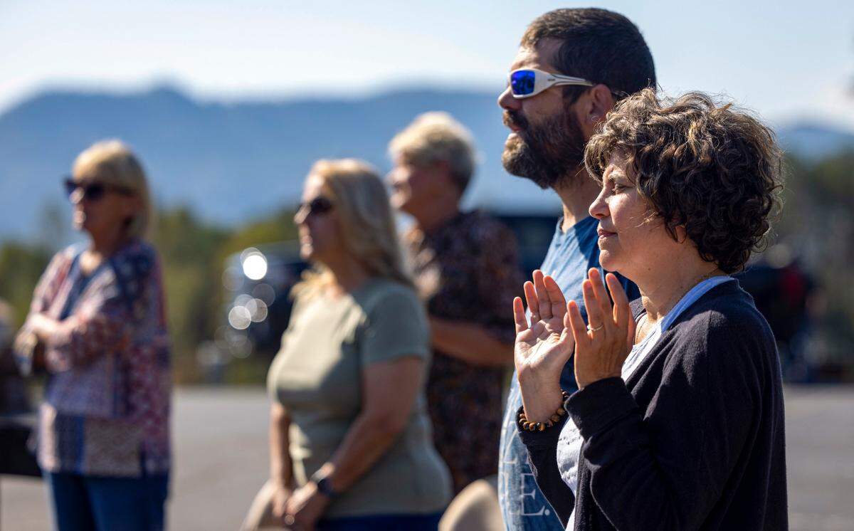 Worshipers pray against the backdrop of the Blue Ridge Mountains at Salem Free Will Baptist Church on Sunday, October 6, 2024 in Old Fort, N.C.