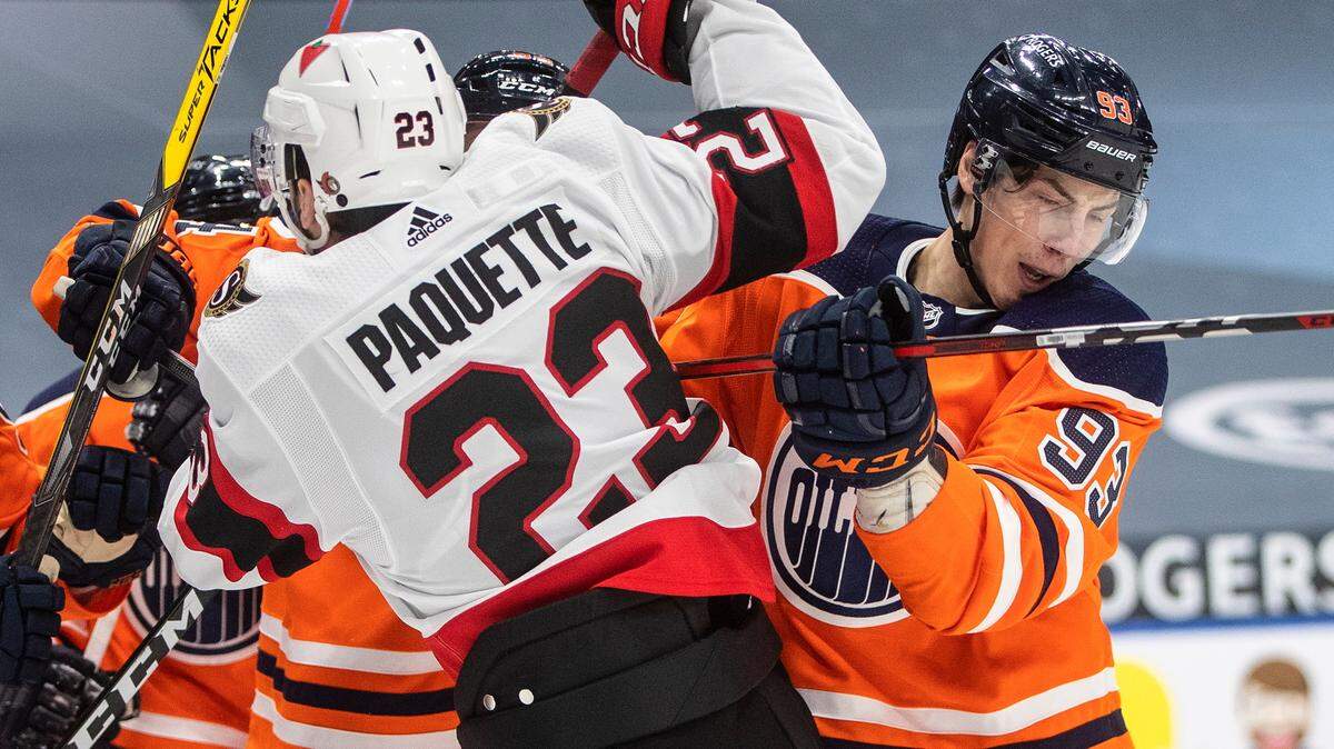 Edmonton Oilers’ Ryan Nugent-Hopkins (93) and Ottawa Senators’ Cedric Paquette (23) rough it up during first-period NHL hockey game action in Edmonton, Alberta, Sunday, Jan. 31, 2021. (Jason Franson/The Canadian Press via AP)