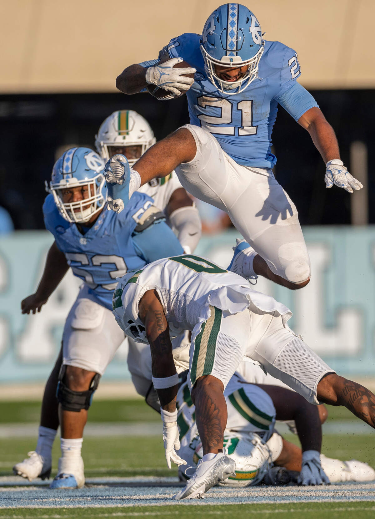 North Carolina running back Davion Gause (21) hurdles over Charlotte defensive back Al-Ma’hi Ali (0) for a 16-yard gain in the fourth quarter on Saturday, September 7, 2024 at Kenan Stadium in Chapel Hill, N.C.