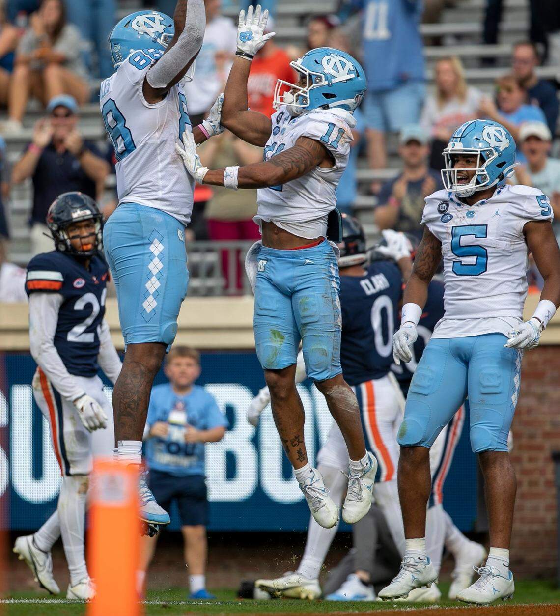 North Carolina’s Josh Downs (11) celebrates with teammate Kamari Morales (88) after scoring a 19-yard pass reception from quarterback Drake Maye in the third quarter to give the Tar Heels’ a 24-21 lead on Saturday, November 5, 2022 at Scott Stadium in Charlottesville, Va.