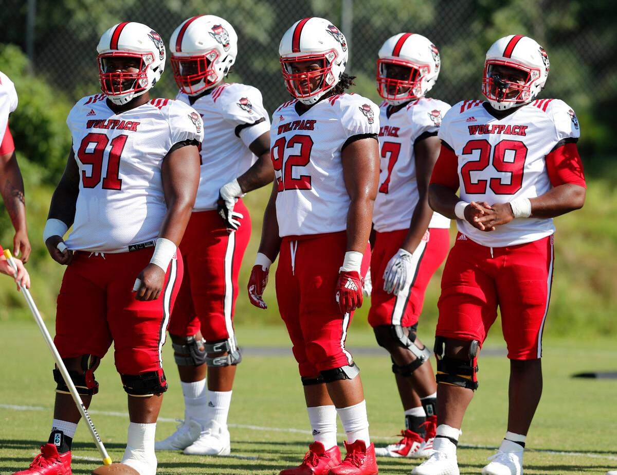From left, Eurndraus Bryant (91), Larrell Murchison (92) and Alim McNeill (29) wait for a drill to start during the Wolfpack’s practice in Raleigh, N.C., Thursday, August 9, 2018.