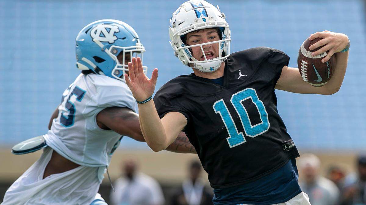 North Carolina quarterback Drake Maye (10) scores a touchdown on a short run while being chased by Kaimon Rucker during a scrimmage at the Tar Heels’ open practice on Saturday, March 25, 2023 at Kenan Stadium in Chapel Hill. N.C.