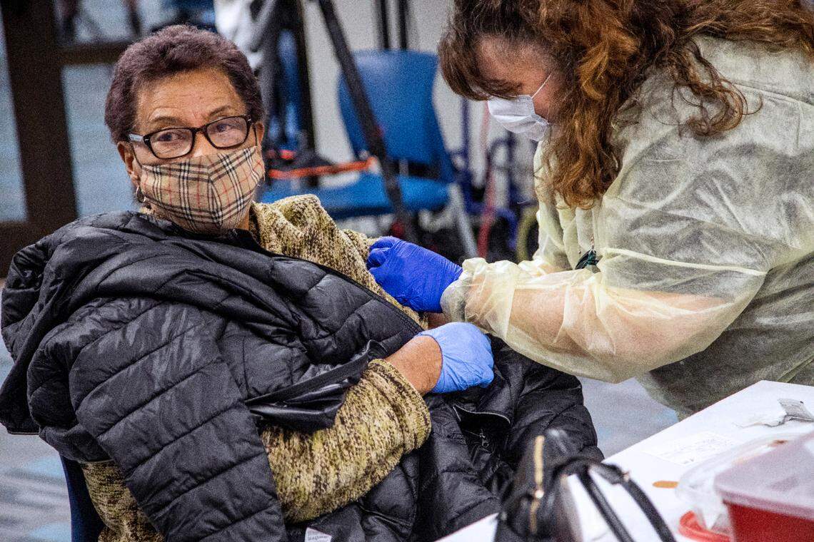 Registered nurse Ronette Dean, right, administers the Pfizer COVID-19 vaccine to Romell Perry, 81, at the Wake County Public Health Center in Raleigh Wednesday, Jan. 27, 2021. The health center currently operates an 6-day-a-week COVID-19 vaccine clinic vaccinating frontline healthcare workers and people over the age of 65.