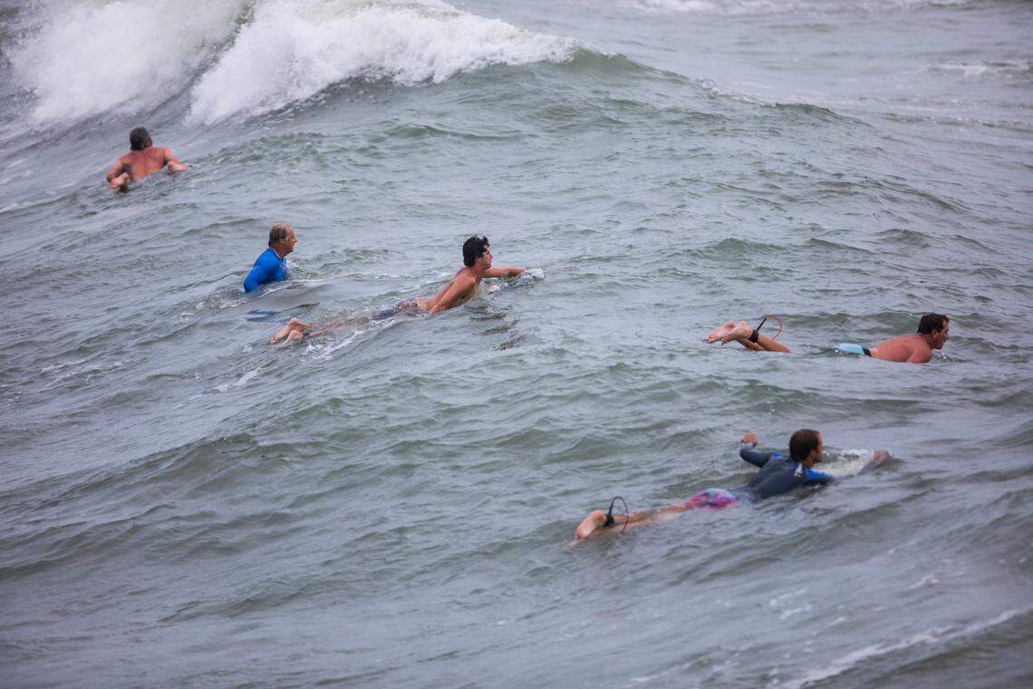 Surfers await waves in big swells brought on by Tropical Storm Isaias near Bogue Inlet Pier in Emerald Isle, N.C. on Monday evening, Aug. 3, 2020.