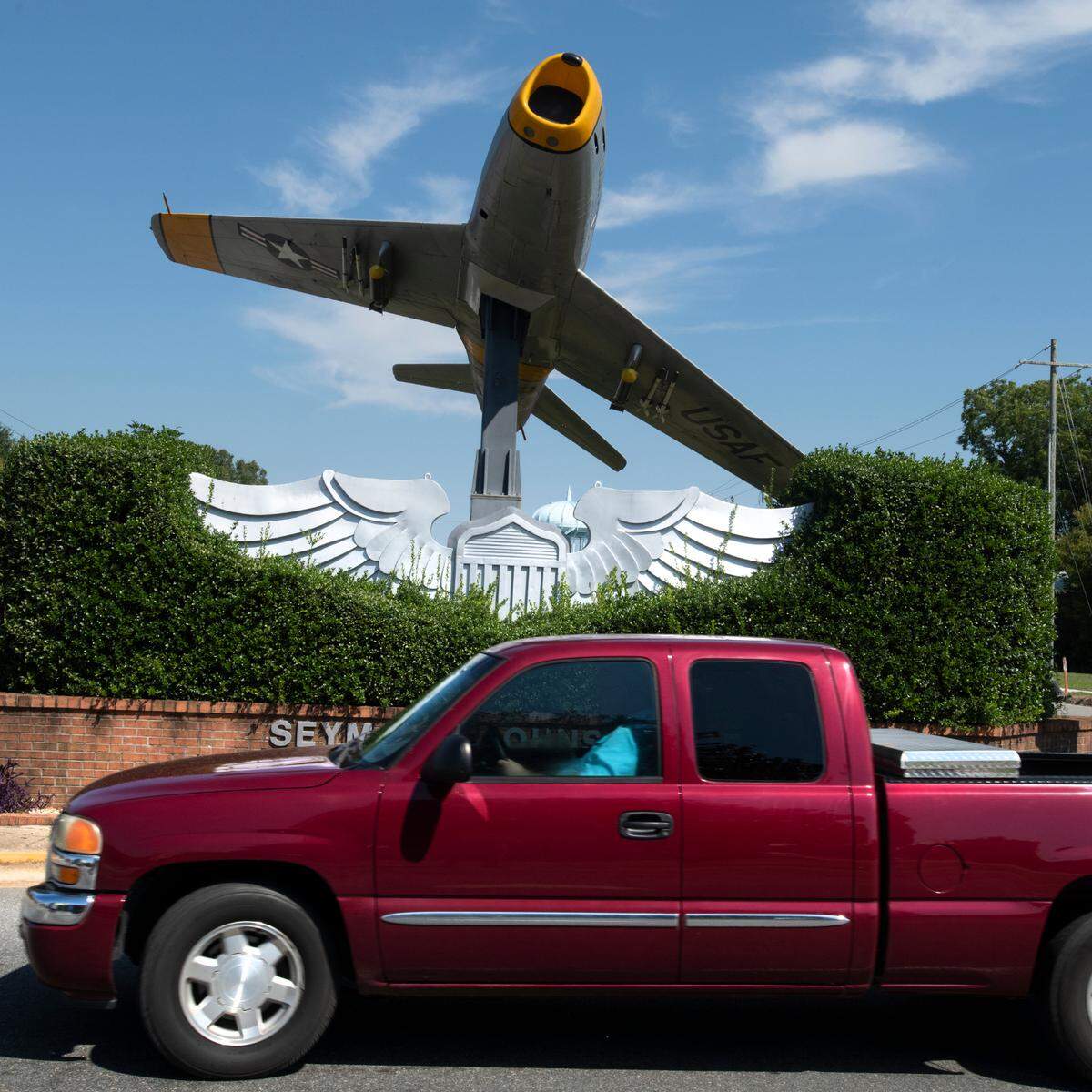 A pickup truck passes a restored F-86 Sabre jet is mounted on a pedestal in a traffic circle in downtown Goldsboro, N.C. It is a monument to forces at nearby Seymour Johnson Air Force Base. The economy of the area is primarily related to the military and agriculture.