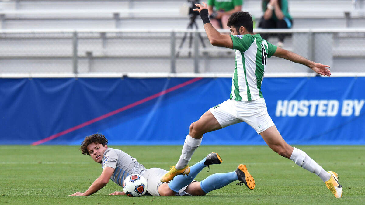 UNC midfielder Cameron Fisher falls to the ground as Marshall’s Gabriel Alves presses forward during the NCAA Tournament’s College Cup semifinals at WakeMed Soccer Park in Cary, N.C. on Friday, May 14, 2021.