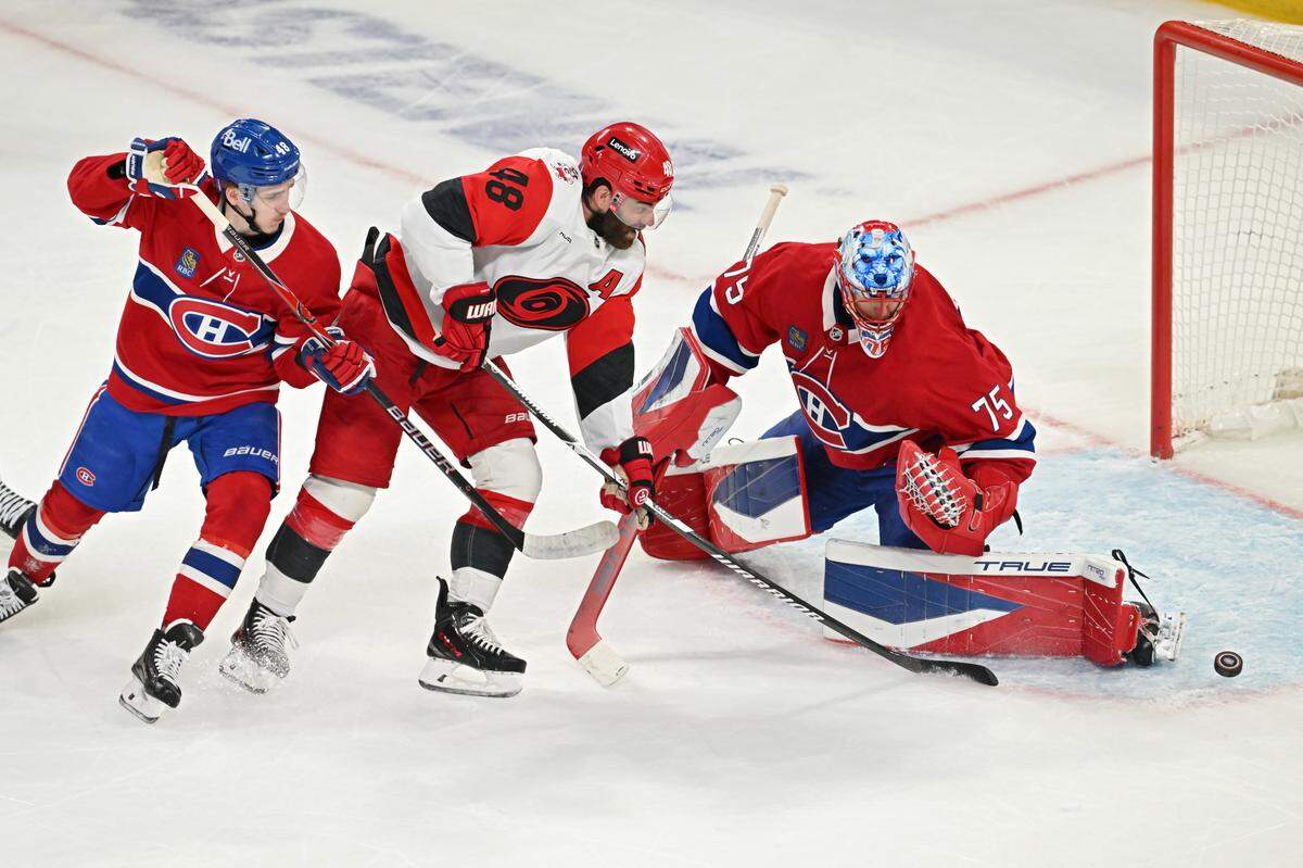 Lane Hutson #48 and Jakub Dobes #75 of the Montreal Canadiens defends the net against against Jordan Martinook #48 of the Carolina Hurricanes during the first period in Game Four of the Eastern Conference Final of the 2026 Stanley Cup Playoffs at Bell Centre on May 27, 2026 in Montreal, Quebec, Canada. 