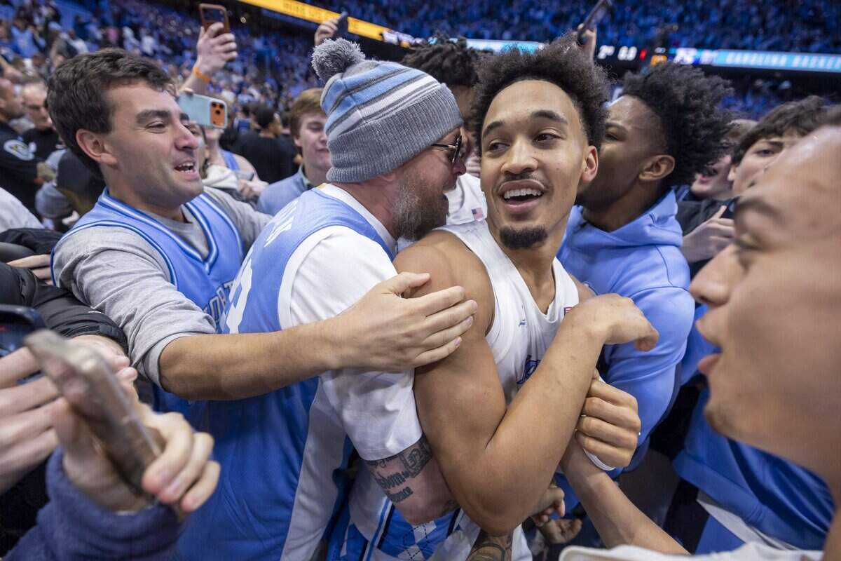 Fans storm the court after North Carolina guard Seth Trimble (7) scored in the final seconds to lift the Tar Heels 71-68 over Duke on Saturday, February 7, 2026 at the Smith Center in Chapel Hill, N.C.