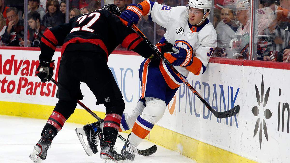 Carolina Hurricanes’ Brett Pesce (22) collides with New York Islanders’ Ross Johnston (32) during the first period of an NHL hockey game in Raleigh, N.C., Friday, April 8, 2022. (AP Photo/Karl B DeBlaker)