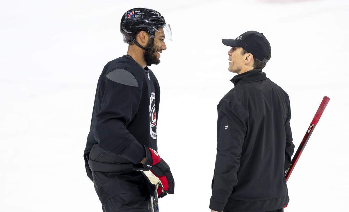 Carolina Hurricanes coach Rod Brind’Amour talks with defenseman K’Andre Miller (19) as they prepare for the Game 1 of the Stanley Cup Playoffs against Las Vegas, on Monday June 1, 2026 at Lenovo Center in Raleigh, N.C.