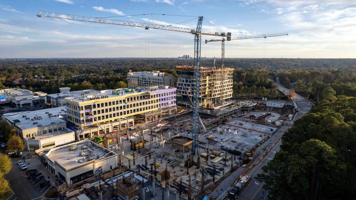 Construction cranes tower over new towers under construction at North Hills in Raleigh Monday, Nov. 14, 2022. The skyline of downtown Raleigh is visible in the background at the center of the horizon.