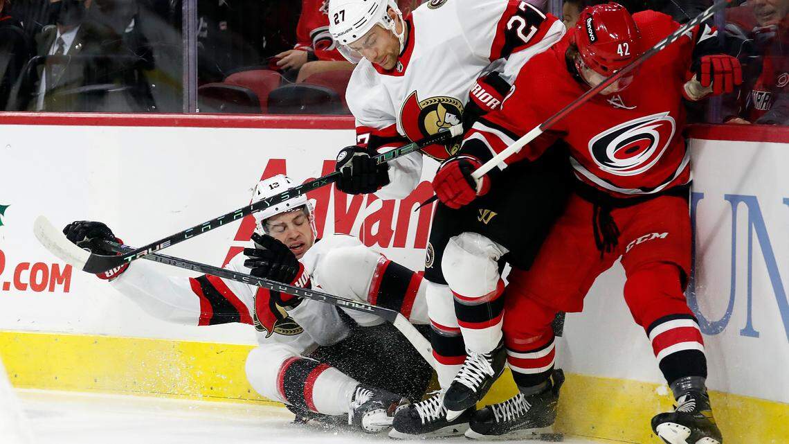 Ottawa Senators’ Zach Sanford (13) joins teammate Dylan Gambrell (27) in vying for the puck against Carolina Hurricanes’ Maxime Lajoie (42) during the first period of an NHL hockey game in Raleigh, N.C., Thursday, Dec. 2, 2021. (AP Photo/Karl B DeBlaker)
