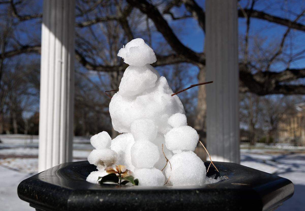 A group of snowmen sits atop the Old Well on Monday, Jan. 26, 2026, in Chapel Hill, N.C.