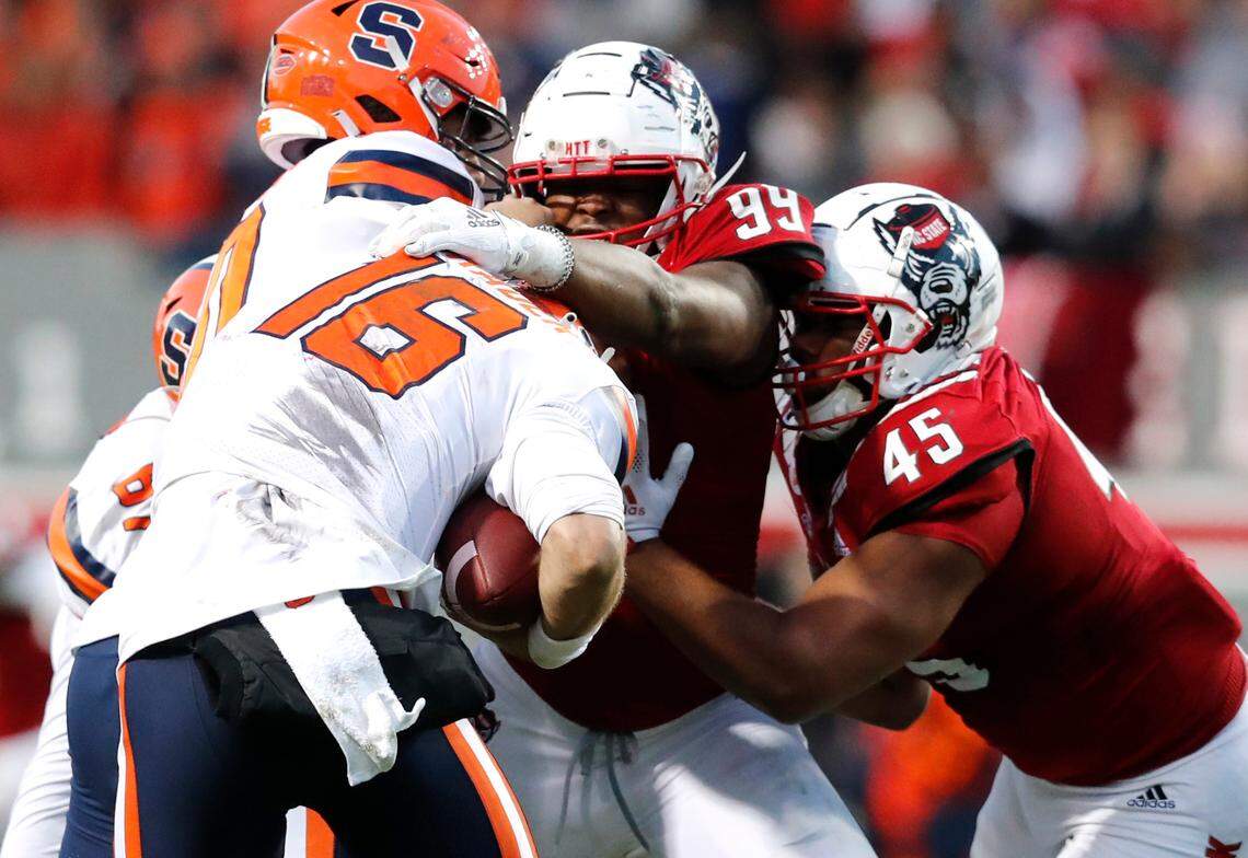 N.C. State’s Daniel Joseph (99) and Davin Vann (45) sack Syracuse quarterback Garrett Shrader (16) during the first half of N.C. State’s game against Syracuse at Carter-Finley Stadium in Raleigh, N.C., Saturday, Nov. 20, 2021.