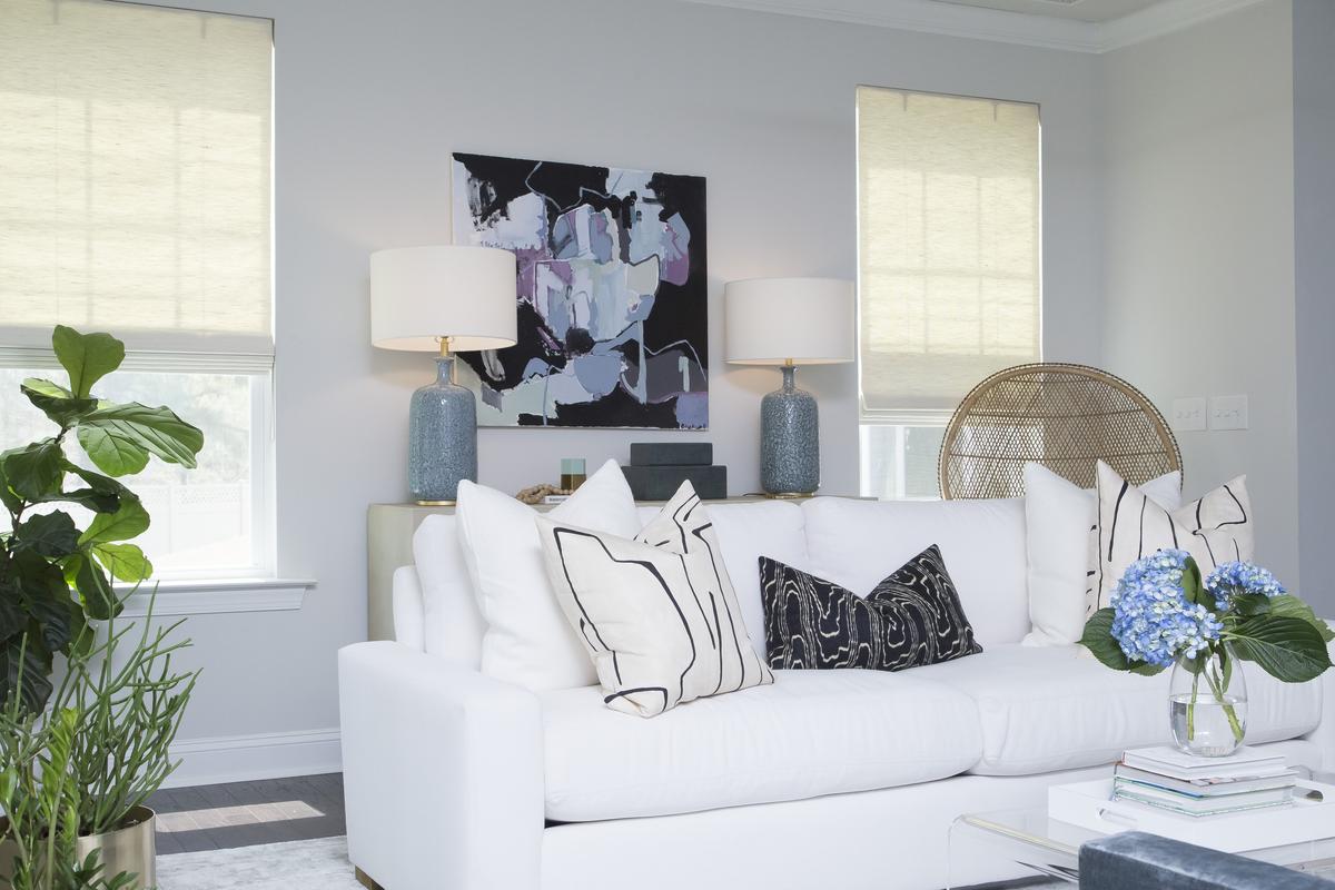 Accessories, plants and modern art with pops of color accent a lightly colored palette.