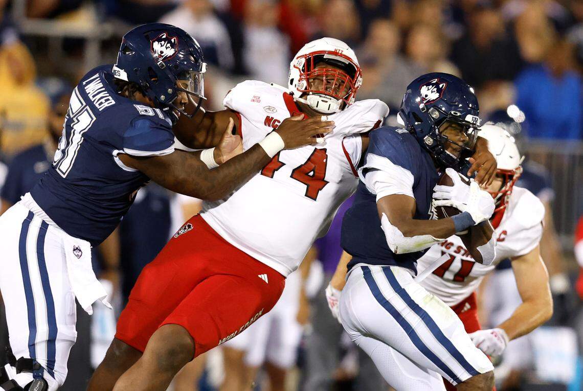 N.C. State defensive lineman Brandon Cleveland (44) avoids the block by Connecticut offensive lineman Yakiri Walker (51) to tackle Connecticut running back Devontae Houston (1) during the second half of N.C. State’s 24-14 victory over UConn at Rentschler Field in East Hartford, Conn. Thursday, August 31, 2023.