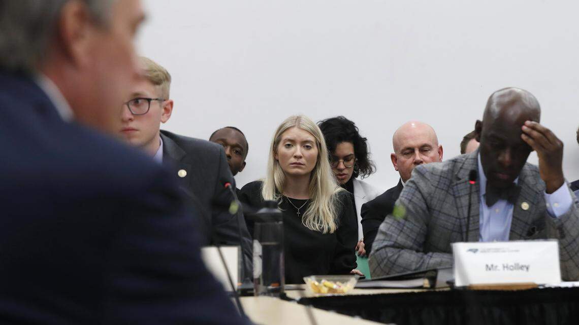 Shelby Hudson, center, listens as East Carolina University Board of Trustees member Phil Lewis resigns while speaking to the Board of Governors during a special meeting Friday, Feb. 7, 2020.